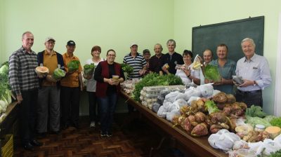 Representantes da Agricultura, Emater, produtores e entidades juntos aos alimentos fornecidos pelo PAA (Foto: Maica Viviane Gebing)